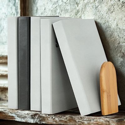 serre livre bambou soutenant livre fond mur gris sur etagere