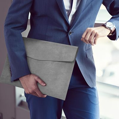 porte document cuir homme regarde montre habit bleu