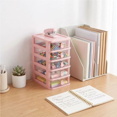 tour de rangement en plastique sur bureau cahier ouvert plante